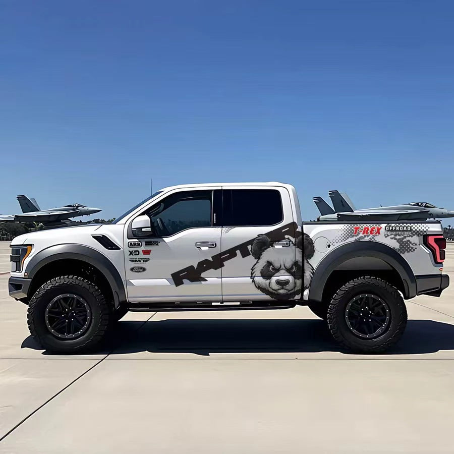 Minimal panda head vinyl wrap on white Ford F-150 Raptor – black and white animal graphic side decal, airfield background