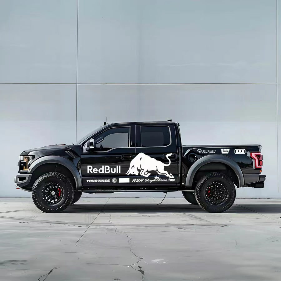 Charging bull vinyl wrap on black Ford F-150 Raptor – white racing sponsor style side graphic, studio background