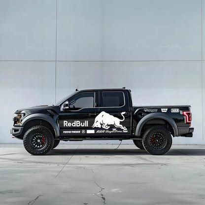 Charging bull vinyl wrap on black Ford F-150 Raptor – white racing sponsor style side graphic, studio background