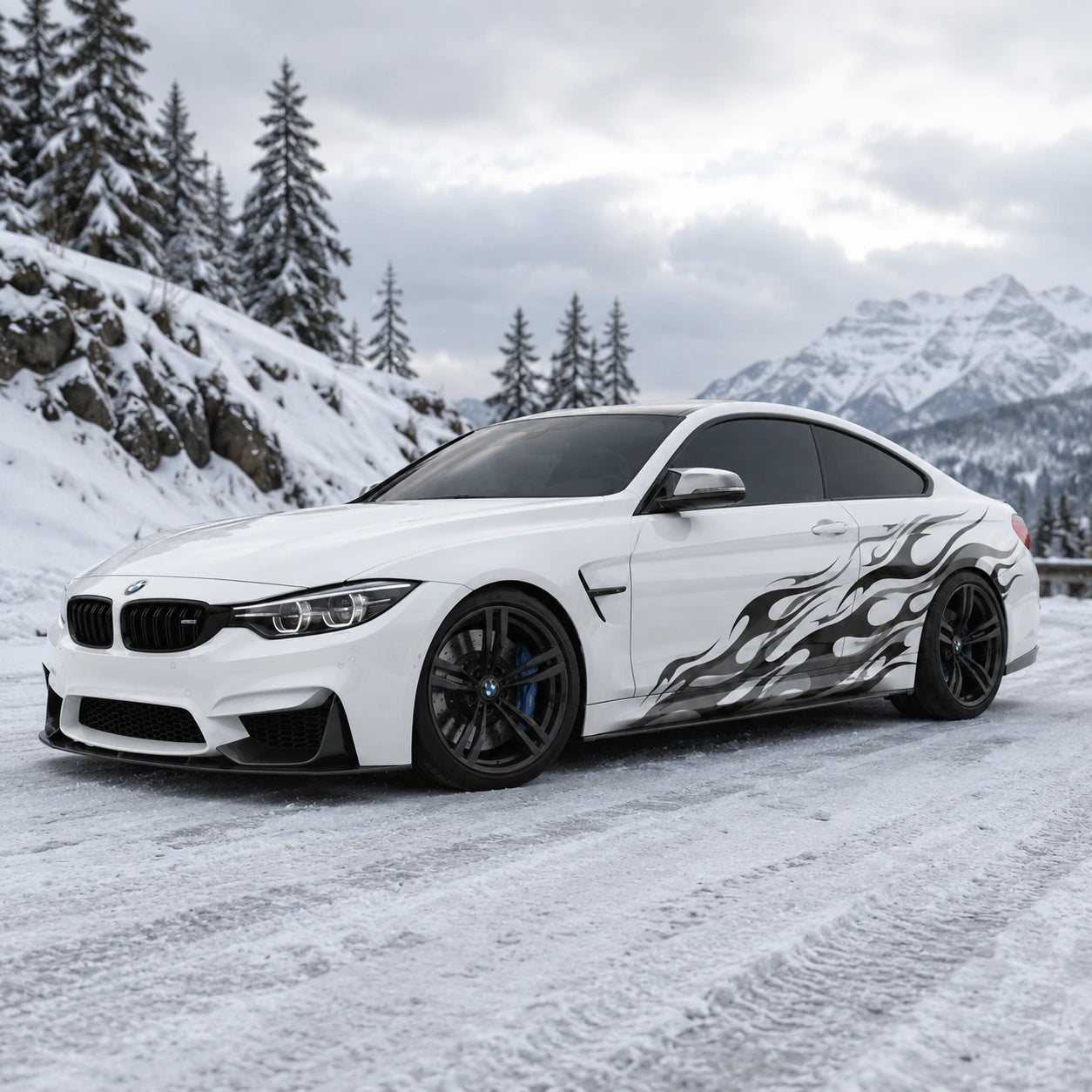 Black flame vinyl car side decal on white BMW M4 – front 3/4 view in snowy mountain setting