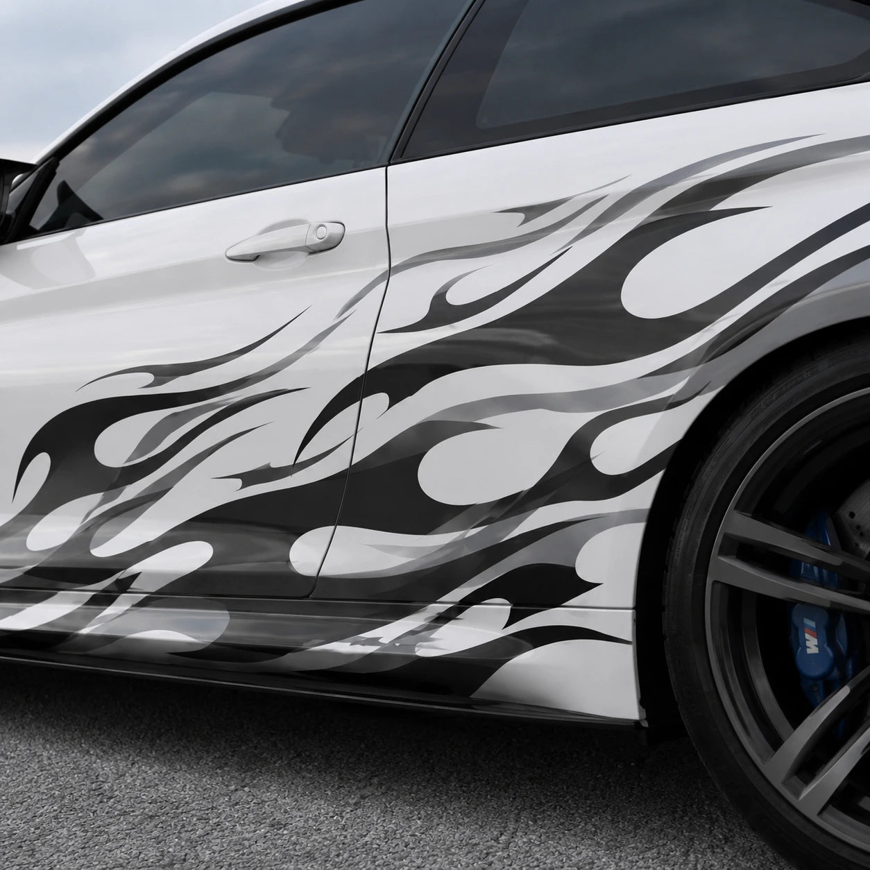 Close-up of black and gray tribal flame vinyl decal applied on white car door panel