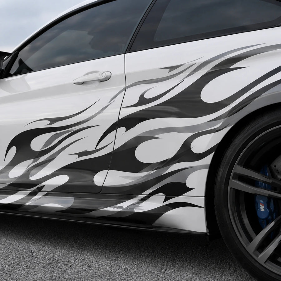 Close-up of black and gray tribal flame vinyl decal applied on white car door panel