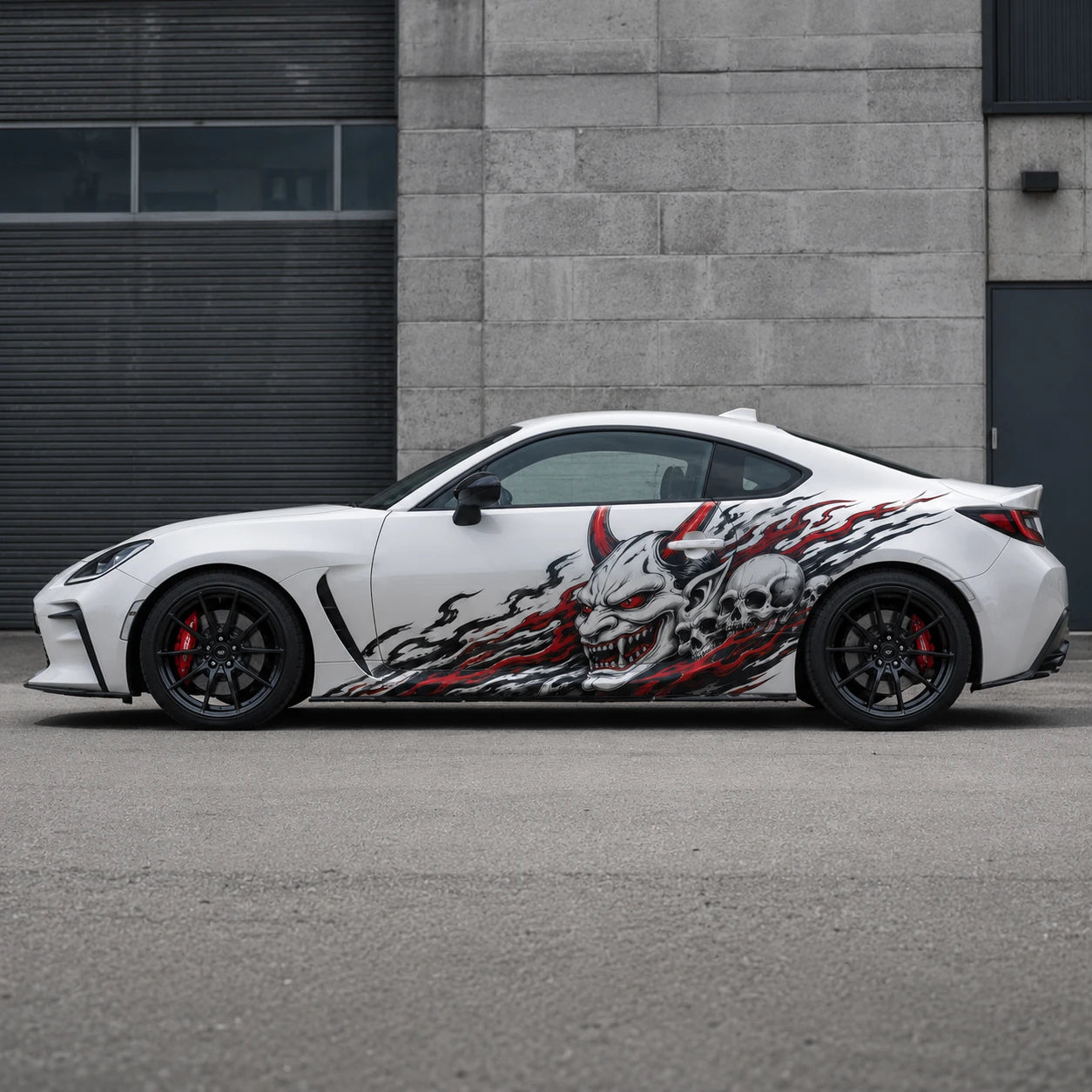 White Toyota GR86 with demon skull side decal – full side profile in urban concrete garage setting
