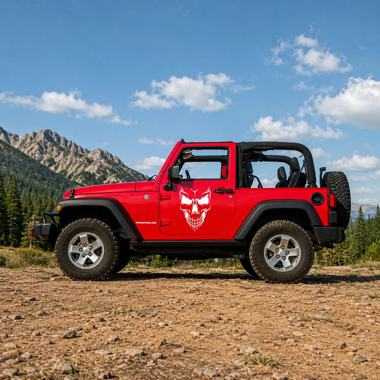 Demon skull vinyl decal installed on red Jeep Wrangler 2-door full side view in mountain landscape