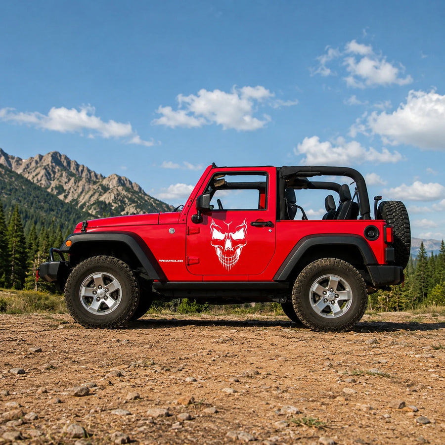 Demon skull vinyl decal installed on red Jeep Wrangler 2-door full side view in mountain landscape