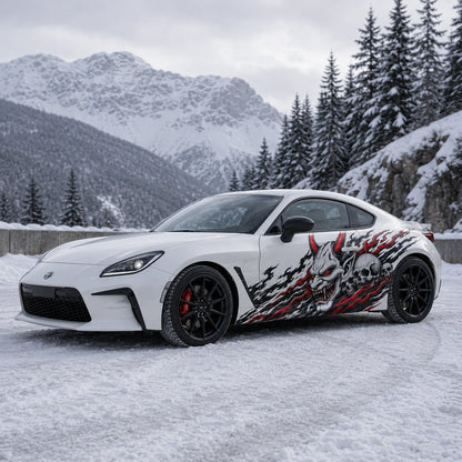 White Toyota GR86 with demon skull flame side decal – front 3/4 view in snowy alpine mountain setting
