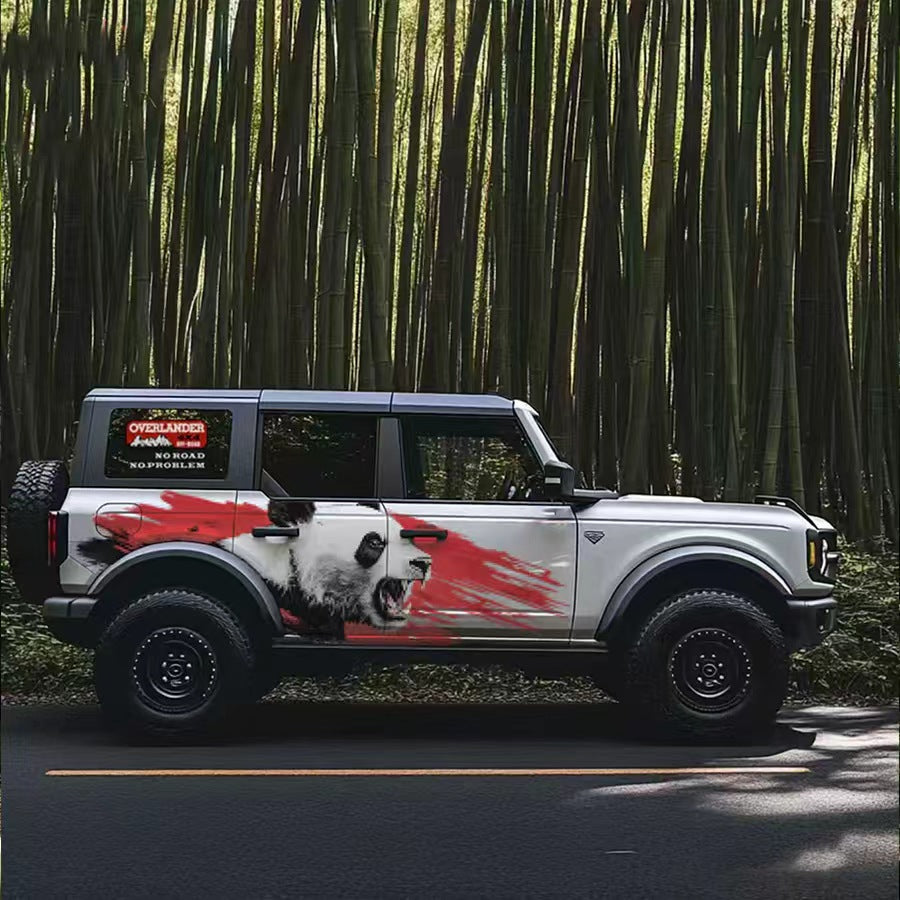 Red brush stroke panda vinyl wrap on white Ford Bronco SUV – aggressive black and red animal side graphic, bamboo forest background