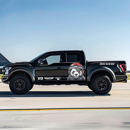 Pilot panda vinyl wrap on black Ford F-150 Raptor – helmet-wearing panda side graphic decal, airfield background