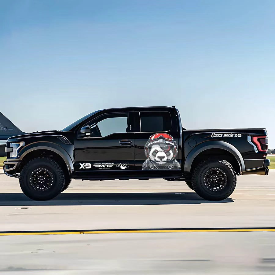 Pilot panda vinyl wrap on black Ford F-150 Raptor – helmet-wearing panda side graphic decal, airfield background