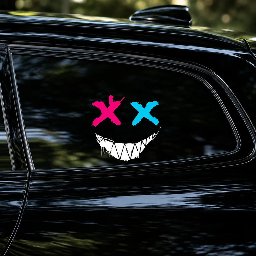 Evil XX smiley face vinyl decal close-up on black car rear side window showing pink X blue X and white jagged grin detail
