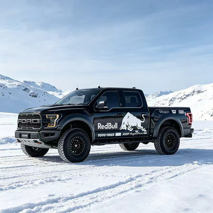 Charging bull truck decal on black Raptor pickup – full side view in snowy outdoor setting