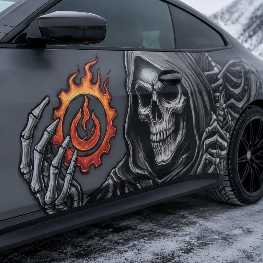 Close-up of grim reaper skull and flaming gear vinyl decal on gray car door panel – detailed artwork view