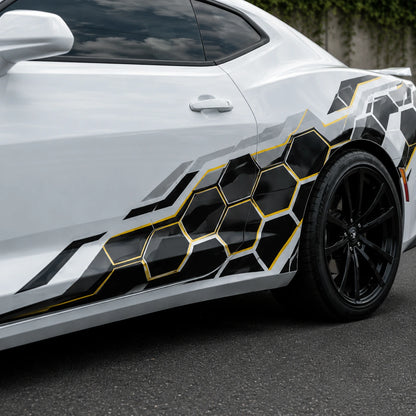 Close-up of black and gold honeycomb hex vinyl decal on white car door panel – detailed geometric pattern view