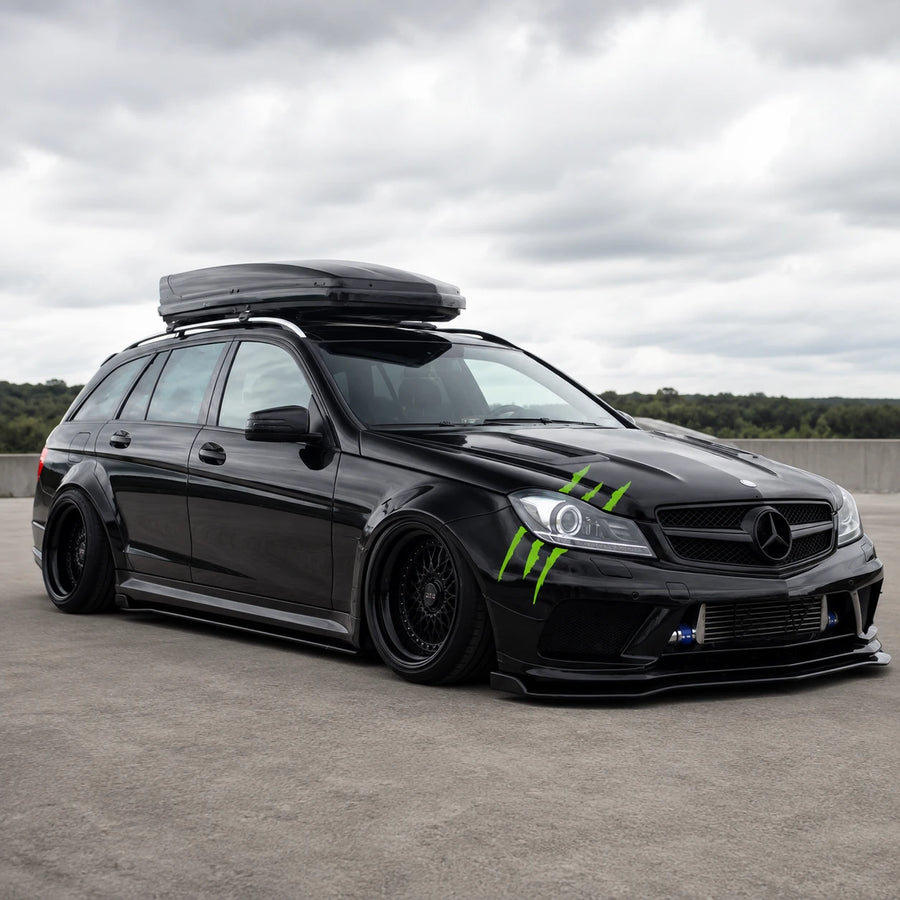 Green monster claw scratch vinyl decal installed on black Mercedes-Benz C-Class AMG wagon full front three-quarter view on rooftop