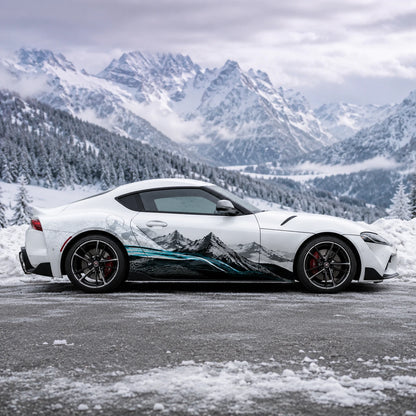 White Toyota Supra GR with mountain landscape side decal – full side profile in snowy alpine mountain valley setting