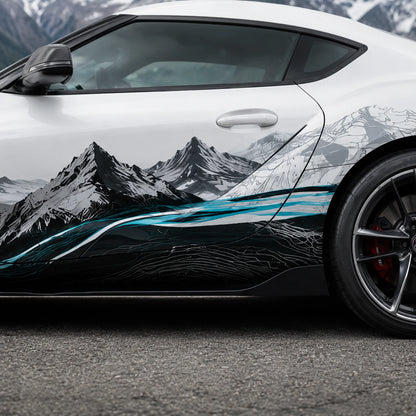 Close-up of black and white mountain peaks with teal river vinyl decal on white Toyota Supra door panel – detailed topographic artwork view