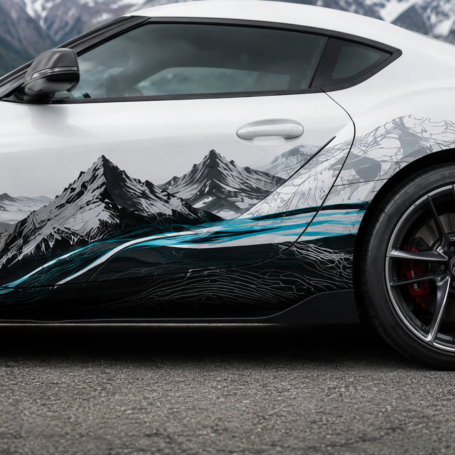 Close-up of black and white mountain peaks with teal river vinyl decal on white Toyota Supra door panel – detailed topographic artwork view