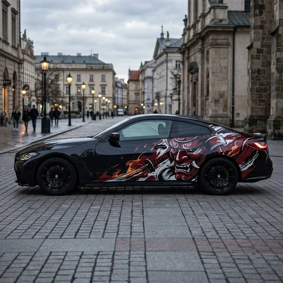 Black BMW M4 with red Oni demon samurai side decal – full side profile on European cobblestone street at dusk