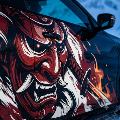 Close-up of red Oni demon mask and flame katana vinyl decal on black car door panel – detailed artwork view
