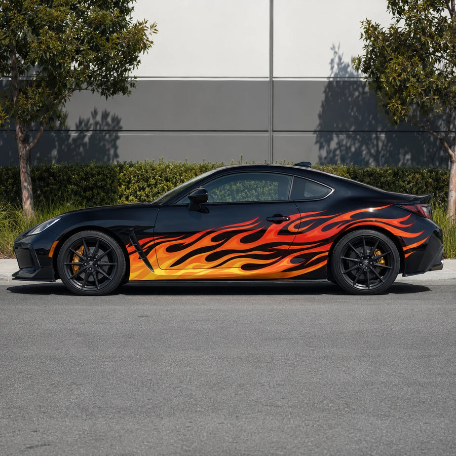 Black Toyota GR86 with orange flame side decal – full side profile in urban parking lot with trees and building backdrop