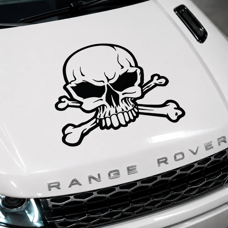 Skull and crossbones vinyl decal close-up on white Range Rover hood showing black skull detail with crossed bones