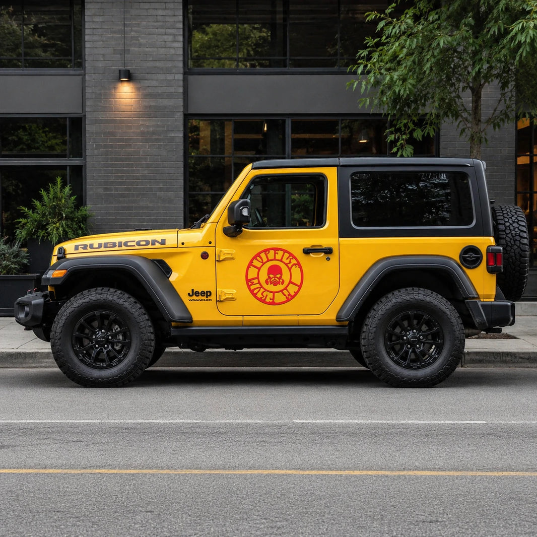 Red skull gas mask circle decal on yellow Jeep Wrangler Rubicon full side view on city street
