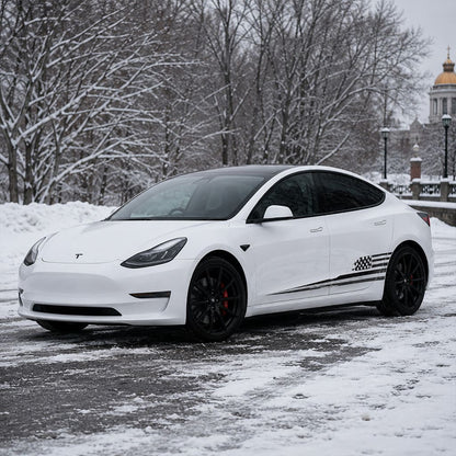 Close-up of Tesla Model 3 American flag side decal showing distressed stars and stripes vinyl detail in snowy forest