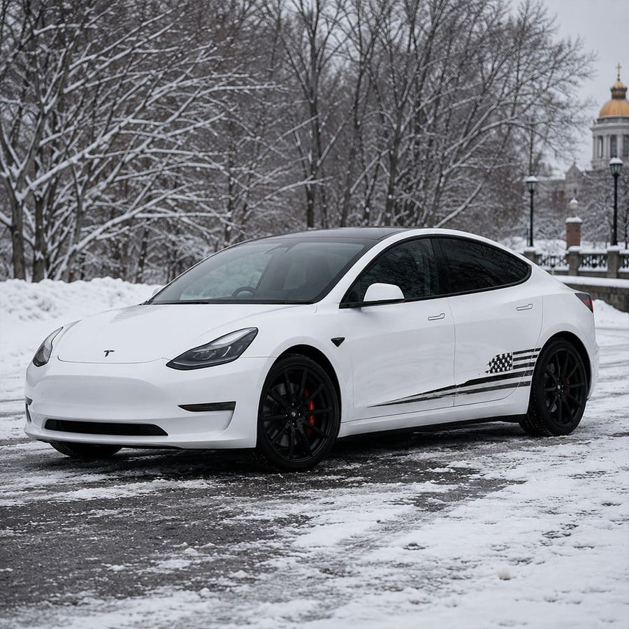 Close-up of Tesla Model 3 American flag side decal showing distressed stars and stripes vinyl detail in snowy forest
