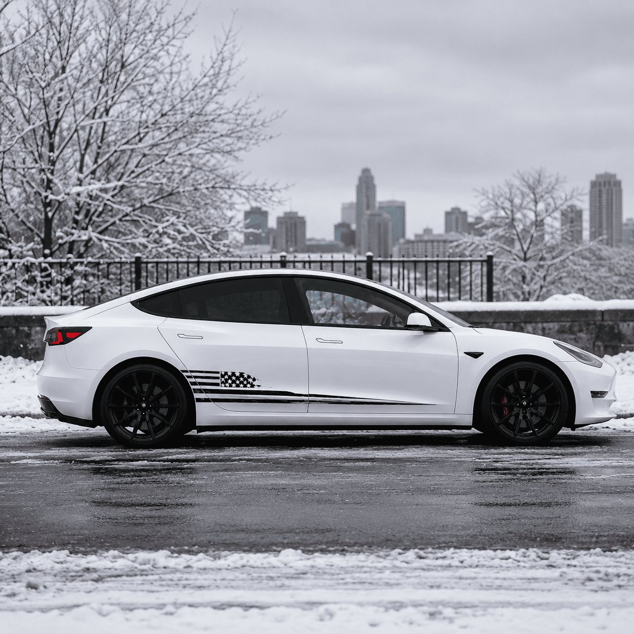 Tesla Model 3 American flag vinyl decal front three-quarter view in snowy historic town setting