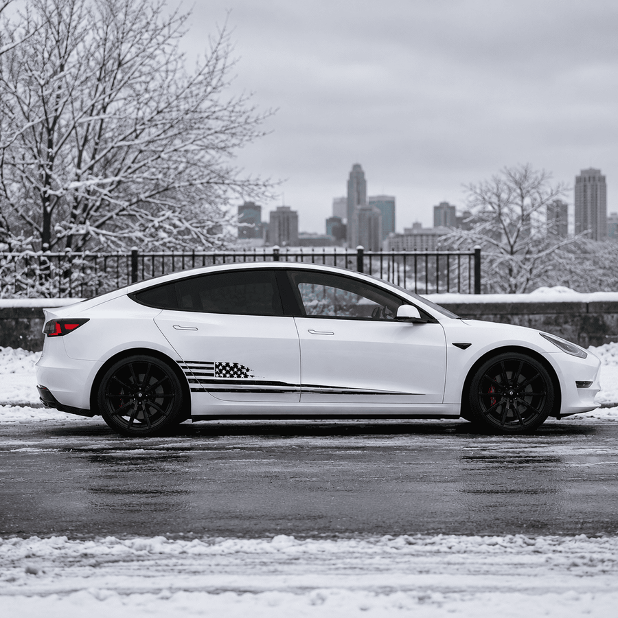 Tesla Model 3 American flag vinyl decal front three-quarter view in snowy historic town setting