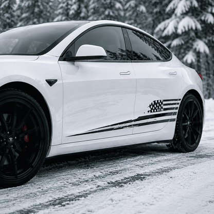 Tesla Model 3 with USA flag side stripe decal parked in snowy urban park with city skyline background