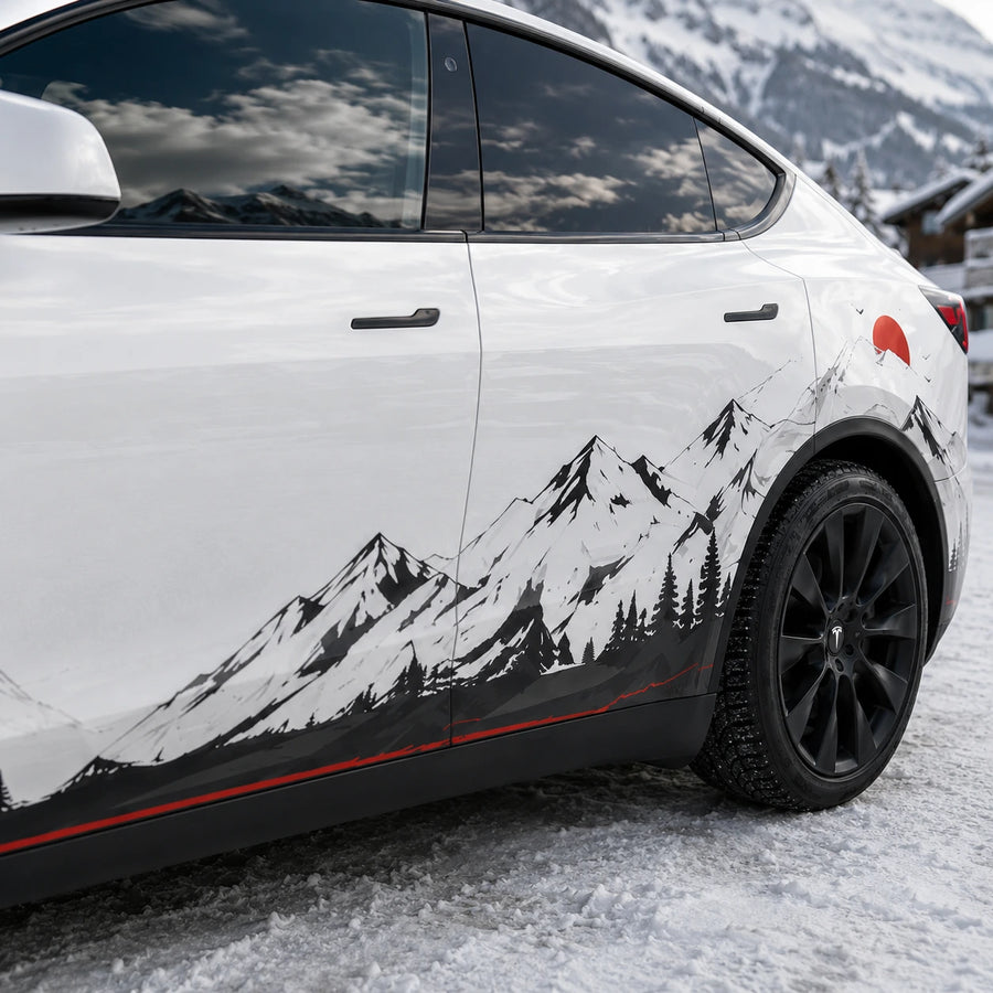 Tesla Model Y black white mountain forest decal close-up door panel snow peak pine tree red sun red pinstripe rocker detail snowy alpine chalet background