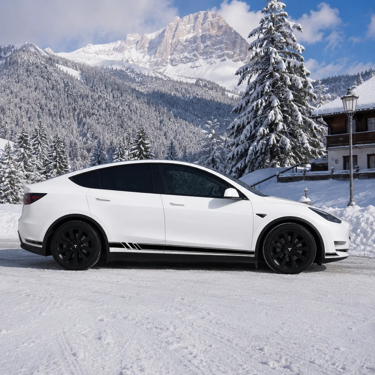 Tesla Model Y black white racing stripe rocker decal full side view snowy alpine chalet mountain pine tree background