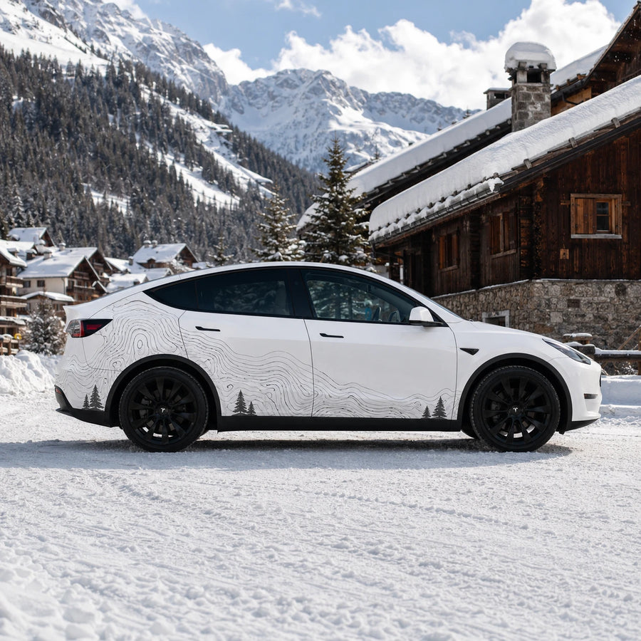 Tesla Model Y topographic contour line car decal full side view snowy alpine mountain chalet background pine tree silhouette