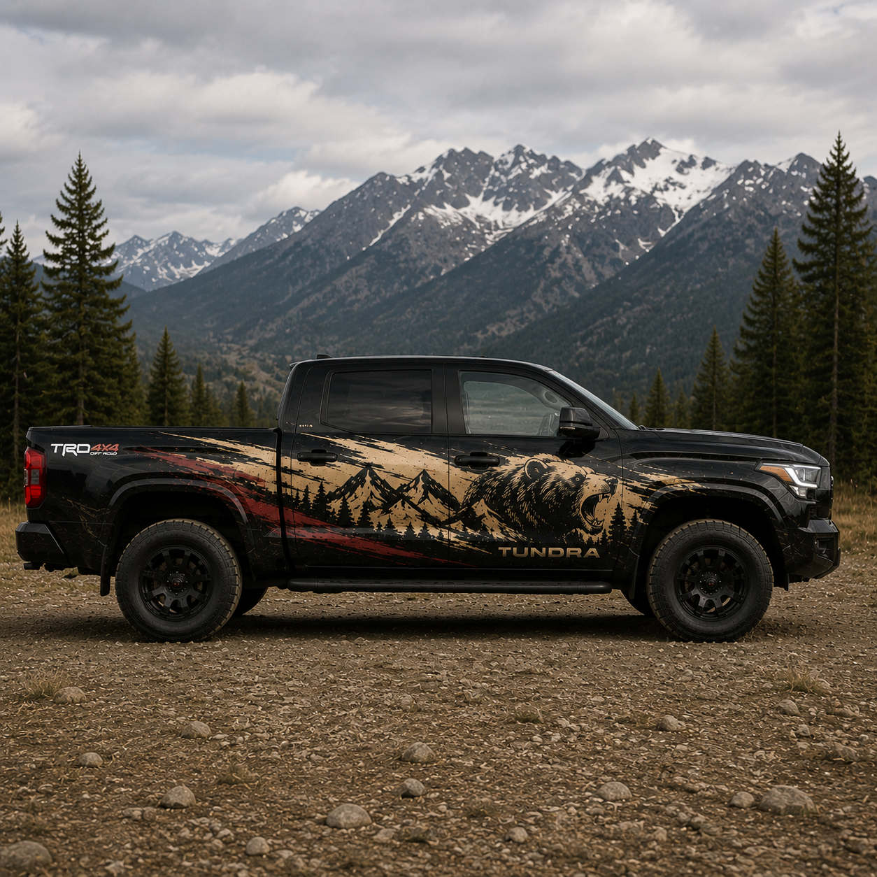 Passenger side view of black Toyota Tundra TRD with bear mountain forest landscape decal in tan, black, and red tones against snow-capped mountain background