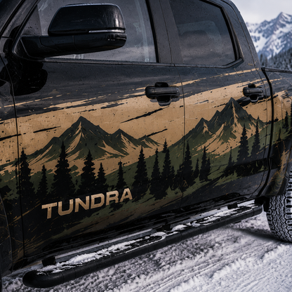 Close-up of Toyota Tundra door panel showing detailed mountain and pine forest landscape decal in tan, olive green, and black tones with TUNDRA lettering