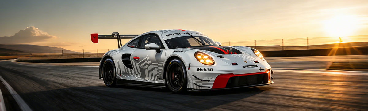 WEEM custom racing decals on white Porsche 911 RSR with red and blue livery on track at sunset – contact support
